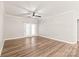 Bright living room features wood-look flooring, ceiling fan, and doors leading to a balcony at 16344 Redstone Mountain Ln, Charlotte, NC 28277