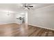 Open living area showcasing wood-look floors, ceiling fan, and view of kitchen area at 16344 Redstone Mountain Ln, Charlotte, NC 28277