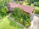 A high angle view reveals lush gardens surrounding the house, along with a driveway and mature trees at 19924 Floral Ln, Cornelius, NC 28031
