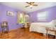 Bedroom with purple walls, hardwood floors, and natural light at 19924 Floral Ln, Cornelius, NC 28031