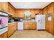 View of the cozy kitchen with wooden cabinets, white appliances, window, and a mix of modern and traditional styles at 19924 Floral Ln, Cornelius, NC 28031
