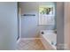 This bathroom has tiled floors, a walk in shower, a tub and large windows at 2043 Shadwell Ct, Gastonia, NC 28056