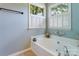 This tub has tiled floors, two windows with shutters, and calming wall color at 2043 Shadwell Ct, Gastonia, NC 28056