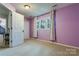 A light purple bedroom with carpet, white trim, window, and natural lighting at 2043 Shadwell Ct, Gastonia, NC 28056