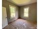 View of a bedroom with two windows and door, showing unfinished flooring and walls at 235 Jefferson E St, York, SC 29745