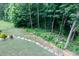 A backyard slopes downhill and features natural landscaping with a stone pathway and mulch at 2405 Emma Grace Ln, Rock Hill, SC 29732