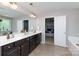 Bright bathroom featuring a double vanity, large mirror, and an open doorway to the main bedroom at 2405 Emma Grace Ln, Rock Hill, SC 29732