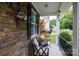 Cozy front porch featuring comfortable seating, stone accents, and decorative hanging plants at 2405 Emma Grace Ln, Rock Hill, SC 29732