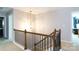 Hallway with carpeted stairs, chandelier, and a wooden banister at 2405 Emma Grace Ln, Rock Hill, SC 29732