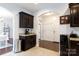 Open kitchen with dark cabinets, stone countertops, and an arched entryway at 2405 Emma Grace Ln, Rock Hill, SC 29732