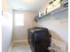 Laundry room featuring modern black washer and dryer set and functional shelving for storage at 2405 Emma Grace Ln, Rock Hill, SC 29732