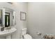 Bright powder room features a pedestal sink, decorative mirror, and neutral decor with a stylish design at 2606 Cheverny Pl, Concord, NC 28027