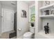 Well-lit bathroom features a toilet and shower with decorated shelving and decor at 2606 Cheverny Pl, Concord, NC 28027