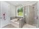 Bright bathroom featuring a tub, separate glass shower, and garden window at 2606 Cheverny Pl, Concord, NC 28027