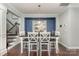 Formal dining room offers a modern table, decorative mirror, and views of staircase and kitchen at 2606 Cheverny Pl, Concord, NC 28027