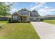 Charming two-story home with stone accents, a well-manicured lawn, and a three-car garage at 2606 Cheverny Pl, Concord, NC 28027