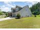 Two-story home with an attached three-car garage, lush lawn, and a fenced yard at 2606 Cheverny Pl, Concord, NC 28027