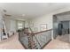 Upstairs hallway with hardwood railing, decorative art, and access to rooms and storage at 2606 Cheverny Pl, Concord, NC 28027