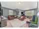 Comfortable carpeted living room with plush furniture, arcade game, and natural light at 2606 Cheverny Pl, Concord, NC 28027