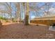Expansive backyard surrounded by trees, features a fire pit and sitting area providing an ideal space for relaxation at 2614 Ocracoke St, Charlotte, NC 28208