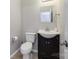 Bathroom featuring a toilet, sink with dark wood cabinet, and wood-look flooring at 2614 Ocracoke St, Charlotte, NC 28208