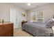 Comfortable bedroom featuring a cozy queen bed, sunny window, dark dresser, and neutral carpet at 2614 Ocracoke St, Charlotte, NC 28208