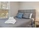 This bedroom offers a comfortable queen bed, cozy gray bedding, bright natural light from a sunny window at 2614 Ocracoke St, Charlotte, NC 28208