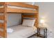 A cozy bedroom features a wooden bunk bed with comfortable bedding and a bedside lamp on a small table at 2614 Ocracoke St, Charlotte, NC 28208