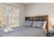 Bedroom features a cozy queen bed, bright window, and dark-wood accents, enhanced by soft, natural lighting at 2614 Ocracoke St, Charlotte, NC 28208