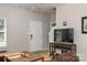 Bright living room with wood floors, neutral walls, and a TV with decorative shelving unit at 2614 Ocracoke St, Charlotte, NC 28208