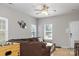 The living room has wood floors, neutral paint, multiple windows, a sofa and a ceiling fan at 2614 Ocracoke St, Charlotte, NC 28208