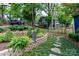 Picturesque backyard with lush landscaping, stone retaining wall, and a view of the surrounding greenery at 27092 Village Dr, Fort Mill, SC 29708