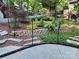 Backyard featuring a retaining wall with lush greenery and a stone pathway leading to the house at 27092 Village Dr, Fort Mill, SC 29708