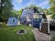 Backyard featuring a spacious deck, fire pit, walkway leading to a shed, and beautiful mature trees at 27092 Village Dr, Fort Mill, SC 29708