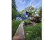 View of blue home, wood deck, nice landscaping, and path to shed in backyard at 27092 Village Dr, Fort Mill, SC 29708