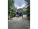 Charming two-story home with blue siding, stone chimney, and detached garage, nestled among mature trees at 27092 Village Dr, Fort Mill, SC 29708