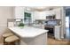 Bright kitchen features a quartz countertop, mosaic backsplash, stainless appliances, and an inviting eat-in bar at 27092 Village Dr, Fort Mill, SC 29708