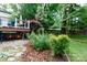 Landscaped backyard with various plants, ground cover, and deck in background at 27092 Village Dr, Fort Mill, SC 29708