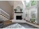 Bright living room with stone fireplace, large windows, and staircase, creating a cozy atmosphere at 27092 Village Dr, Fort Mill, SC 29708