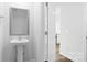 Half-bathroom featuring a pedestal sink, white trim, and view to kitchen area at 3136 Ora Smith Rd, Lincolnton, NC 28092