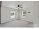 Spacious bedroom features neutral carpeting, a ceiling fan, and large windows, creating a calm and inviting space at 321 E Taylor St, Landis, NC 28088