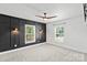 Stylish bedroom with a modern accent wall, gray carpet, ceiling fan, and natural light from two windows at 321 E Taylor St, Landis, NC 28088