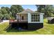 Side view showing a deck and a large window, with a well-kept lawn at 321 E Taylor St, Landis, NC 28088