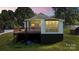Cozy home showing a wooden deck and large window, with a well-kept lawn at 321 E Taylor St, Landis, NC 28088