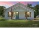 Charming single-story home with a well-manicured lawn, front porch, American flag, and rustic wooden shutters at 321 E Taylor St, Landis, NC 28088