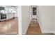 Hallway features hardwood flooring and neutral paint leading to the kitchen, creating a bright and open flow at 321 E Taylor St, Landis, NC 28088