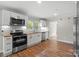 Updated kitchen features stainless appliances, butcher block countertops, white cabinetry, and hardwood flooring at 321 E Taylor St, Landis, NC 28088