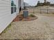 Side yard with dormant lawn, landscaping and air conditioning unit at 3629 Cerelia Ln, Denver, NC 28037