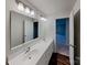 Bathroom with double sink vanity, a large mirror, and hardwood flooring at 3629 Cerelia Ln, Denver, NC 28037