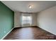 Bright bedroom with hardwood flooring, accent wall, and large window at 3629 Cerelia Ln, Denver, NC 28037